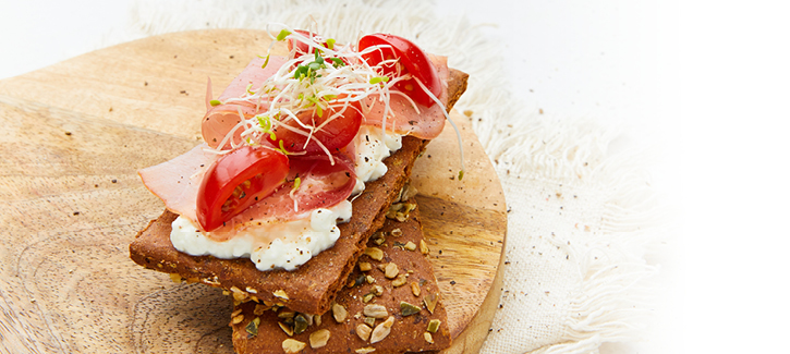 Crackers met rauwe ham, tomaatjes en alfalfa